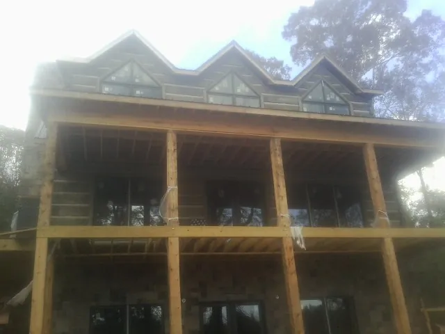 Dormers and porch framing on a large log home under construction — Roof Coating work by our crew in Pottsville