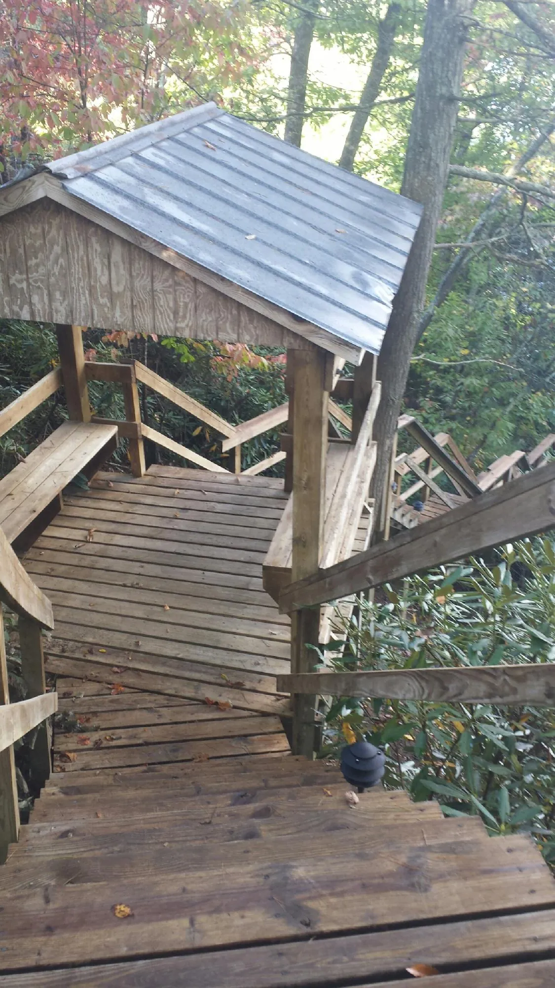 Metal roofed shelter over wooden steps on a wooded walkway — Skylight Repair & Installation work by our crew in Pottsville